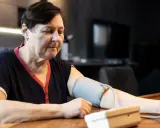 Kobieta mierzy ciśnienie, które wynosi 143 na 93. Wynik jest niepokojący.