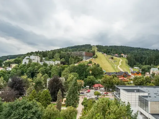 Widok na Krynicę-Zdrój z trasą narciarską i zabudowaniami. Sprawdź sanatorium krynica zdrój cennik.