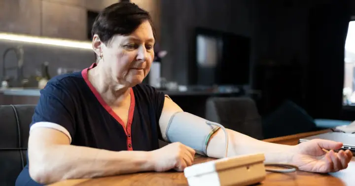 Kobieta mierzy ciśnienie, które wynosi 143 na 93. Wynik jest niepokojący.